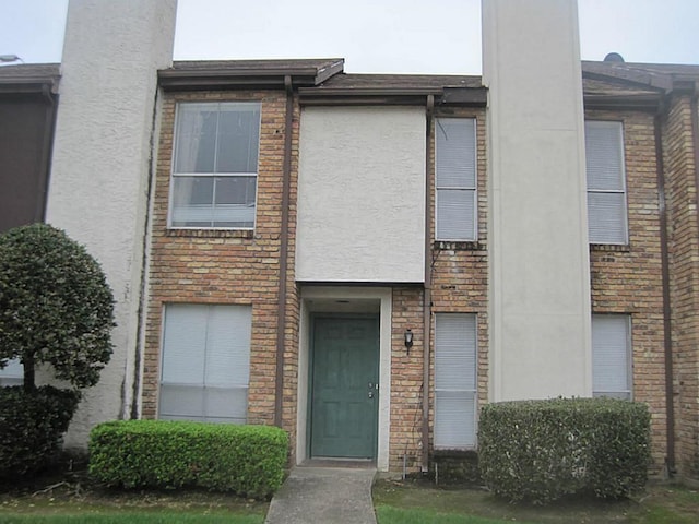 townhome / multi-family property featuring brick siding and stucco siding