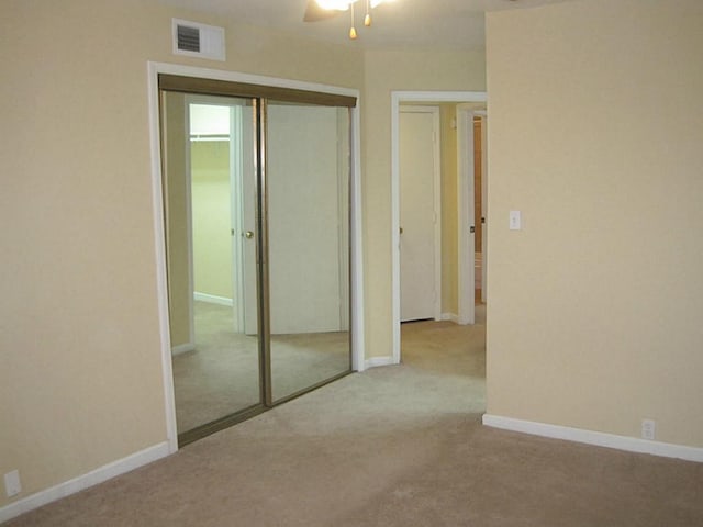unfurnished bedroom with visible vents, a ceiling fan, carpet floors, a closet, and baseboards