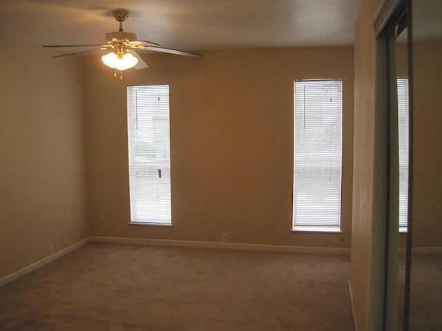 unfurnished room with baseboards, carpet, and ceiling fan
