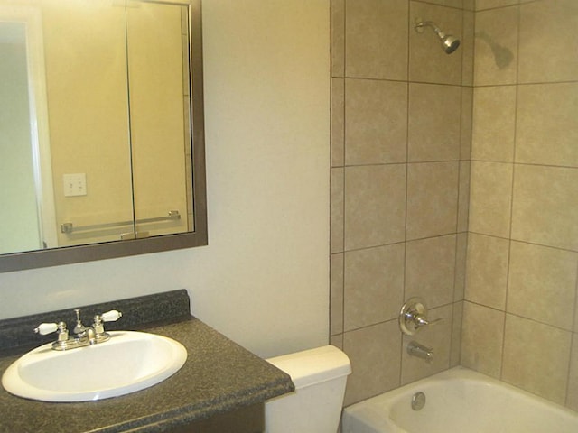 bathroom with vanity, washtub / shower combination, and toilet