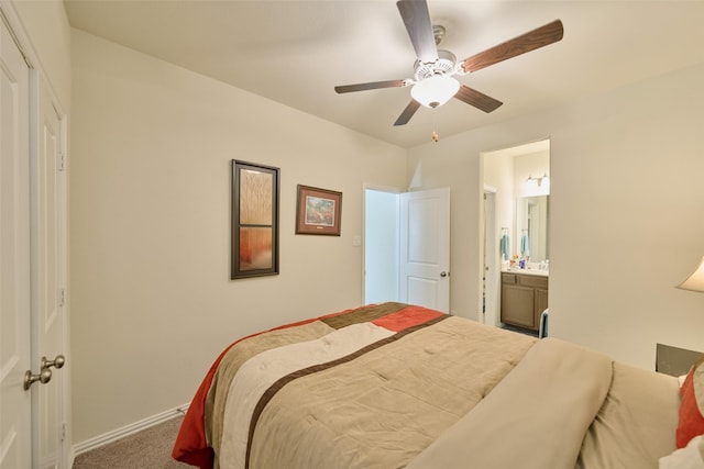 carpeted bedroom featuring baseboards, ensuite bathroom, and ceiling fan