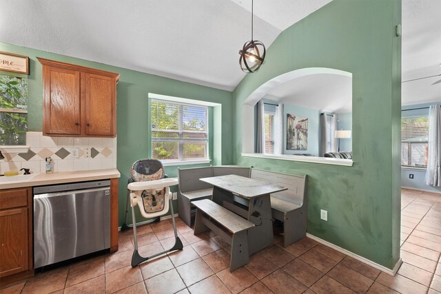 dining space with plenty of natural light, arched walkways, lofted ceiling, and light tile patterned flooring