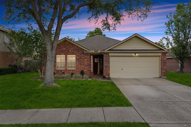 ranch-style home with roof with shingles, brick siding, concrete driveway, an attached garage, and a yard