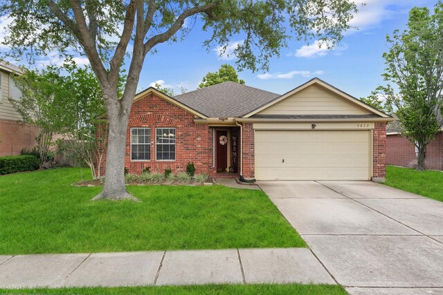 ranch-style house featuring driveway, a front yard, roof with shingles, brick siding, and an attached garage