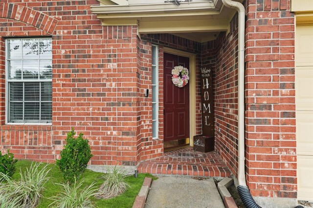 doorway to property featuring brick siding