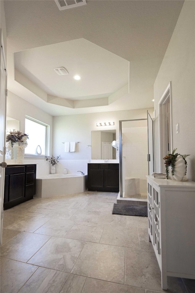 2757 Maxway Ct, League City, TX 77573 - full bathroom featuring a shower stall, visible vents, a tray ceiling, two vanities, and a garden tub