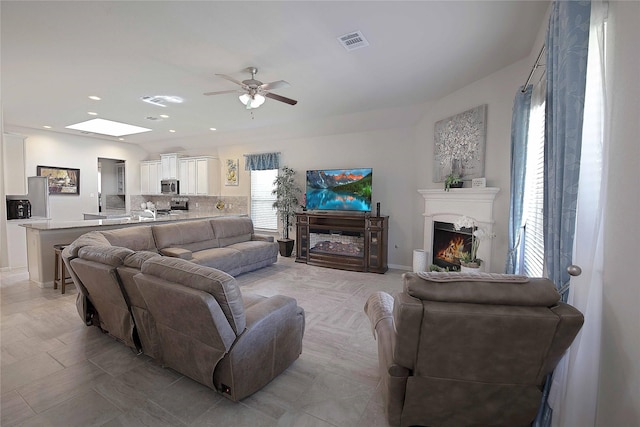 2757 Maxway Ct, League City, TX 77573 - living room featuring visible vents, a ceiling fan, and a lit fireplace