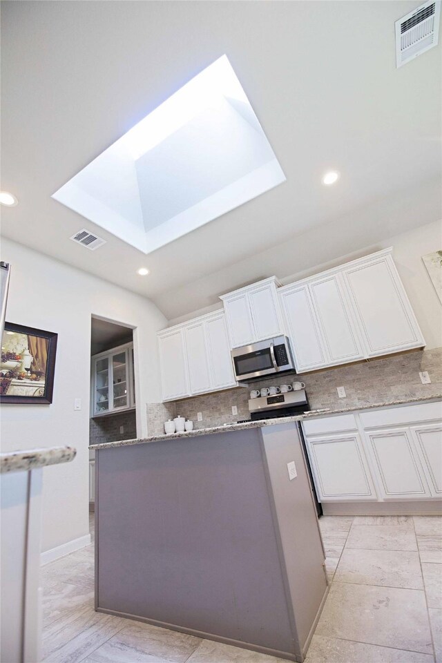 2757 Maxway Ct, League City, TX 77573 - kitchen with a skylight, visible vents, stainless steel appliances, and decorative backsplash