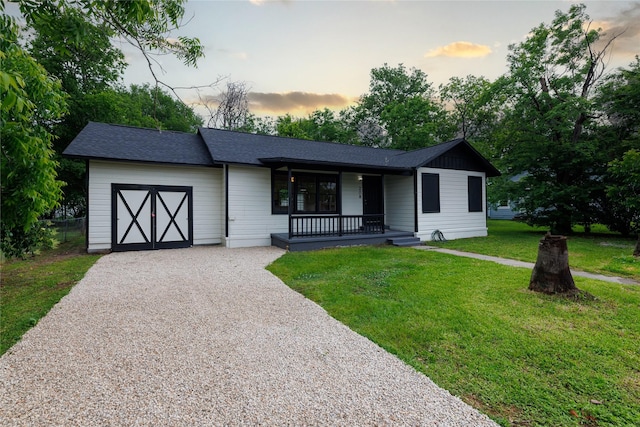 208 W Jefferson St, Trinity, TX 75862 - ranch-style house featuring a porch, an attached garage, driveway, a front lawn, and roof with shingles
