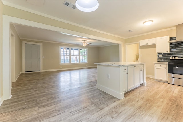 208 W Jefferson St, Trinity, TX 75862 - kitchen with stainless steel electric range oven, ornamental molding, white cabinets, light wood-style floors, and a ceiling fan