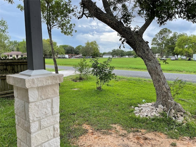 view of home's community featuring fence and a lawn