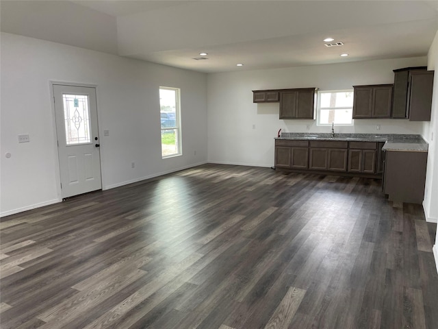 kitchen featuring recessed lighting, dark brown cabinetry, baseboards, and dark wood-style flooring