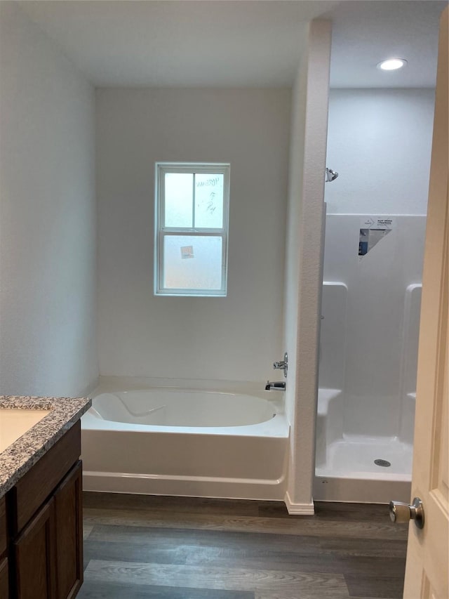 full bathroom with a garden tub, vanity, wood finished floors, and a shower