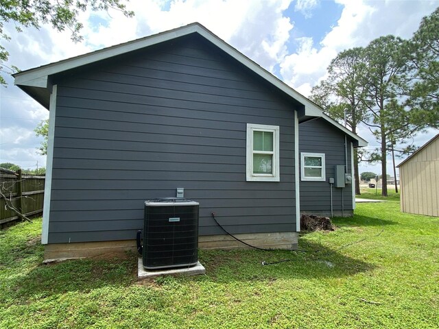 view of side of property with a yard and cooling unit