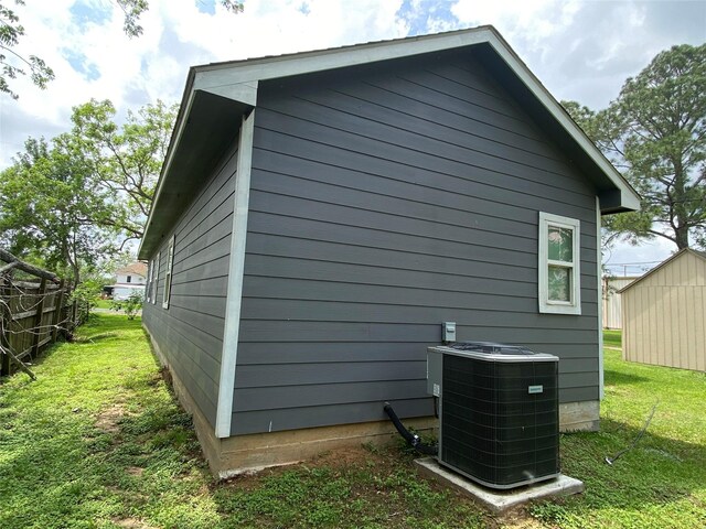 view of home's exterior with a lawn and central AC