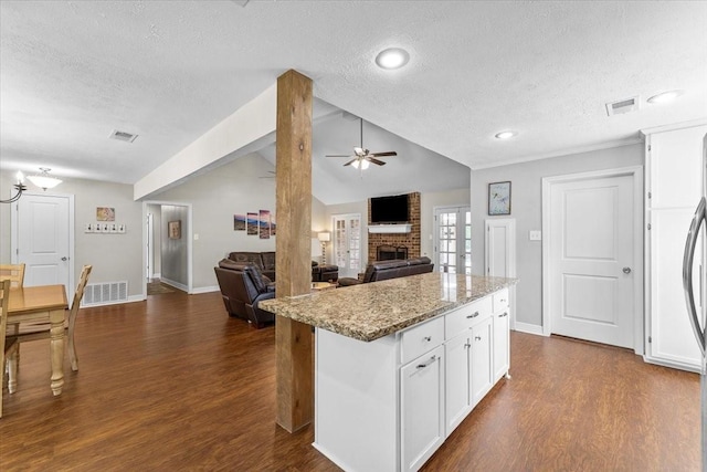 kitchen with ceiling fan, dark wood-style floors, a textured ceiling, and visible vents