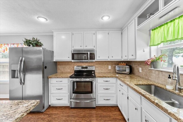 kitchen featuring a sink, white cabinetry, a healthy amount of sunlight, and stainless steel appliances