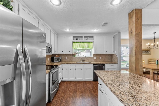kitchen featuring appliances with stainless steel finishes, white cabinets, a textured ceiling, and dark wood-type flooring