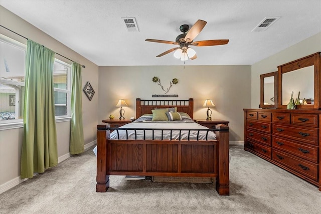bedroom with baseboards, visible vents, and light carpet