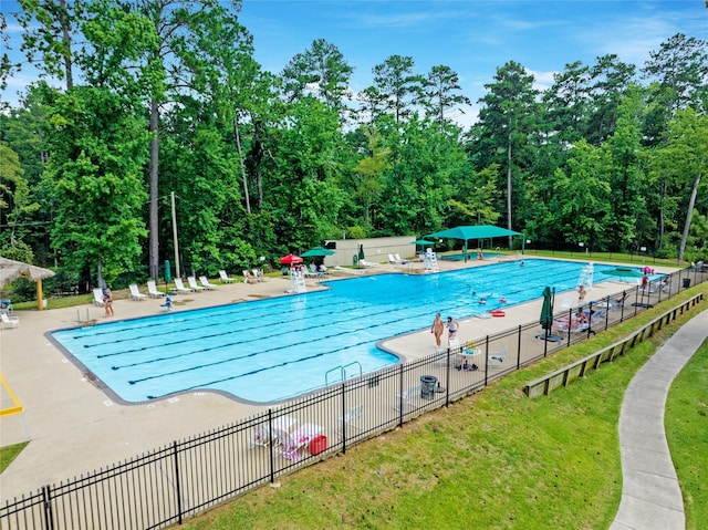 community pool with a patio and fence