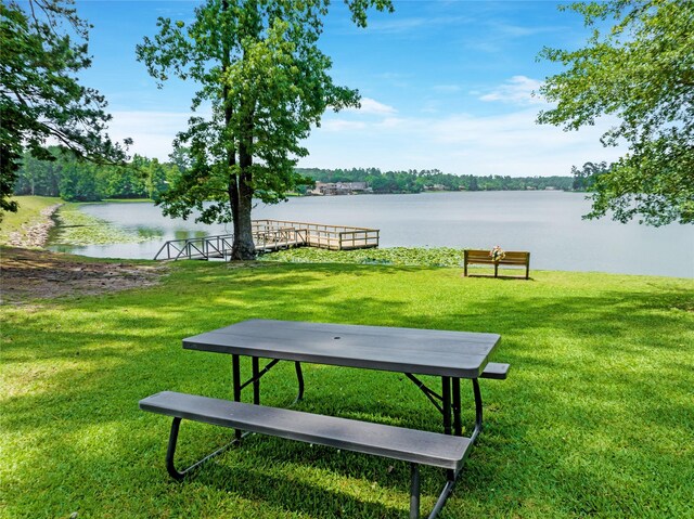 view of property's community featuring a lawn and a water view