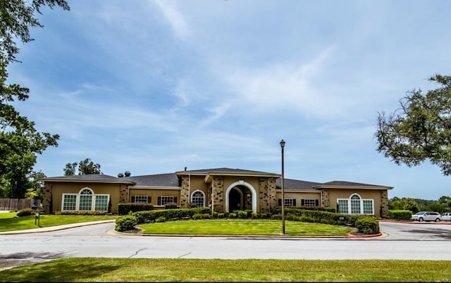 mediterranean / spanish-style house with stucco siding and a front lawn