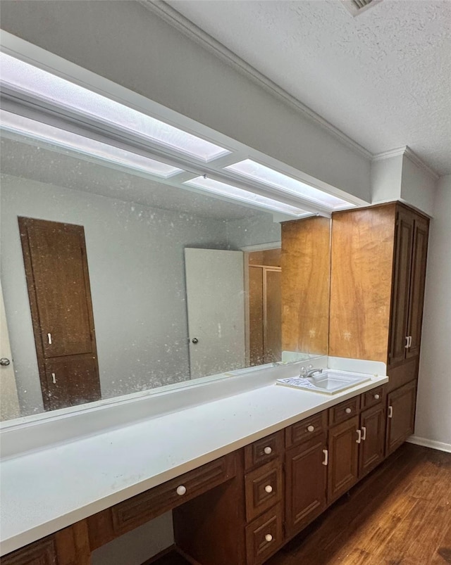 200 Greenwood Dr, Beaumont, TX 77705 - full bathroom featuring wood finished floors, a textured ceiling, vanity, and ornamental molding