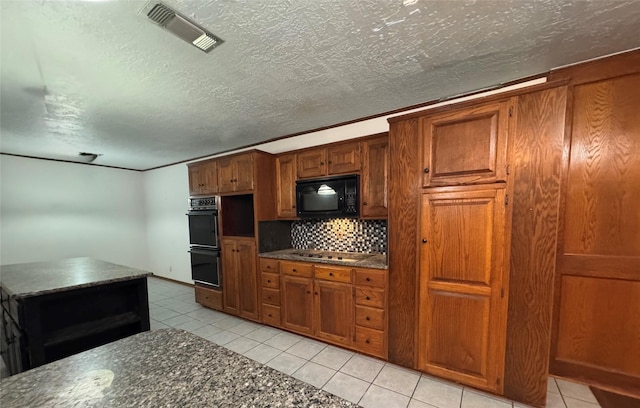200 Greenwood Dr, Beaumont, TX 77705 - kitchen with visible vents, backsplash, black appliances, brown cabinetry, and light tile patterned floors