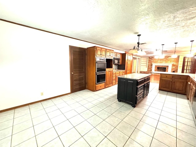 200 Greenwood Dr, Beaumont, TX 77705 - kitchen with decorative light fixtures, black appliances, a textured ceiling, and a fireplace