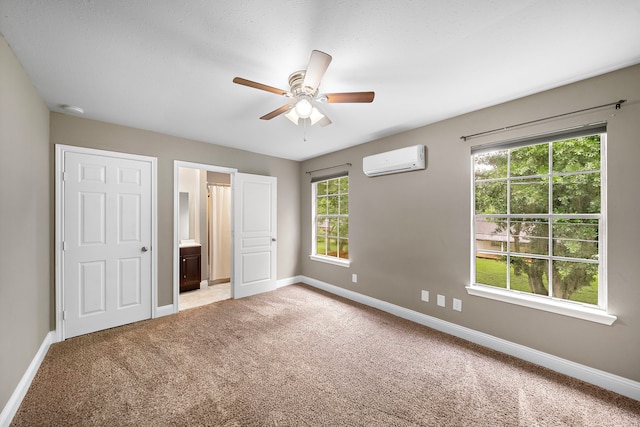 1111 Robert St, Pearland, TX 77581 - unfurnished bedroom featuring a wall unit AC, baseboards, light colored carpet, ensuite bath, and a ceiling fan