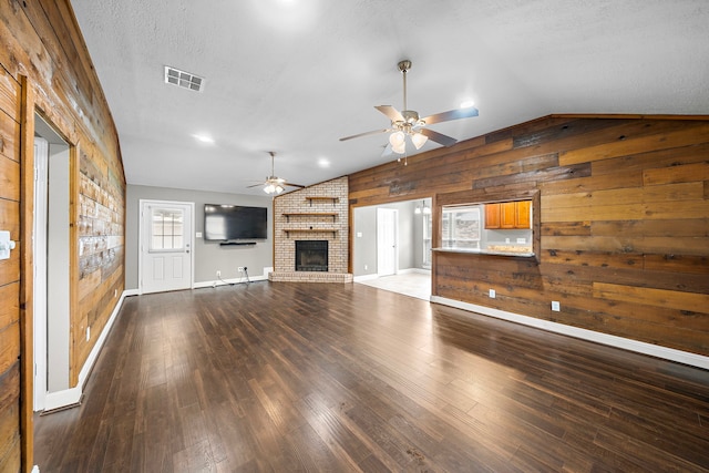 1111 Robert St, Pearland, TX 77581 - unfurnished living room with vaulted ceiling, wooden walls, a ceiling fan, baseboards, and wood finished floors