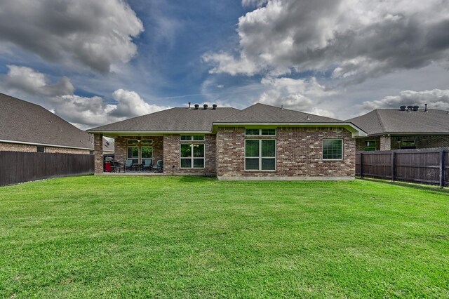 rear view of property with a patio area, a lawn, and a fenced backyard