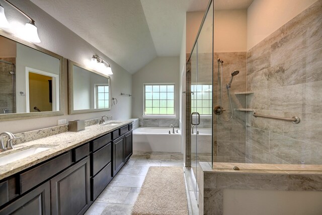 bathroom featuring lofted ceiling, a bath, a sink, and a stall shower