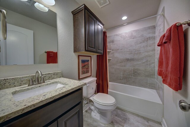 full bath featuring toilet, shower / bath combo with shower curtain, vanity, and visible vents