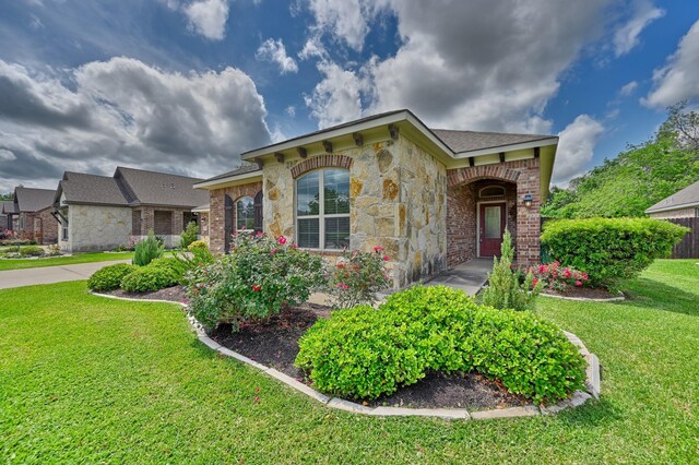 view of front of property with brick siding, stone siding, and a front yard