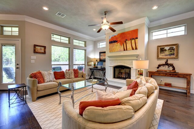 living room with a wealth of natural light, a ceiling fan, wood finished floors, and visible vents