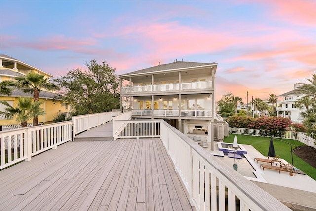 deck at dusk with a storage shed, fence, and a patio area