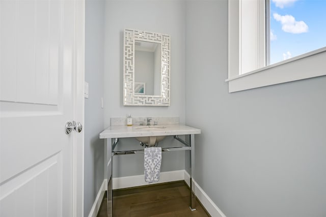 bathroom featuring a sink, baseboards, and wood finished floors