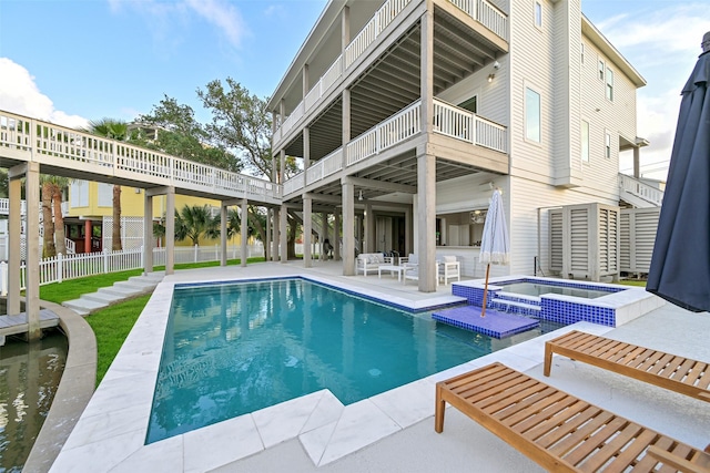 view of swimming pool featuring a patio area, fence, and a pool with connected hot tub