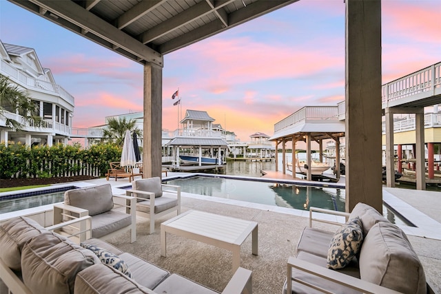 view of swimming pool featuring an outdoor living space, a water view, boat lift, and a dock