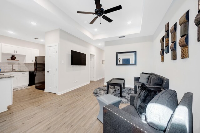 living area featuring recessed lighting, light wood finished floors, visible vents, a ceiling fan, and baseboards