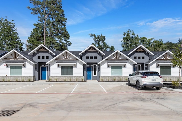view of front of property featuring uncovered parking and brick siding