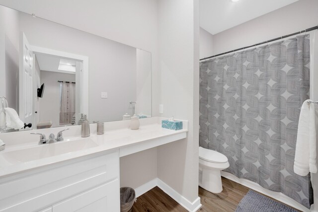 bathroom with wood finished floors, vanity, baseboards, toilet, and a shower with shower curtain
