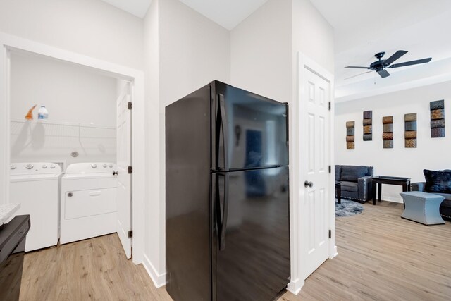 kitchen featuring light wood-style flooring, baseboards, freestanding refrigerator, independent washer and dryer, and ceiling fan
