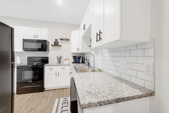 kitchen featuring open shelves, backsplash, a sink, black appliances, and white cabinetry