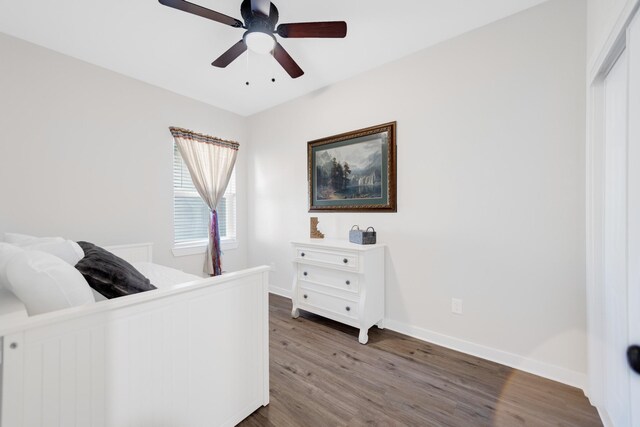 bedroom featuring baseboards, wood finished floors, and ceiling fan