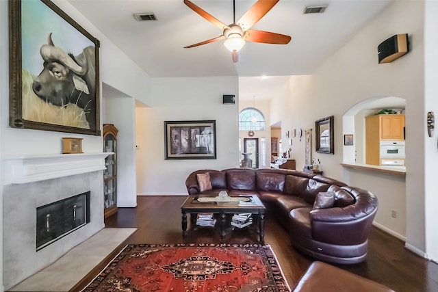 living room with a fireplace with flush hearth, wood finished floors, visible vents, and a ceiling fan