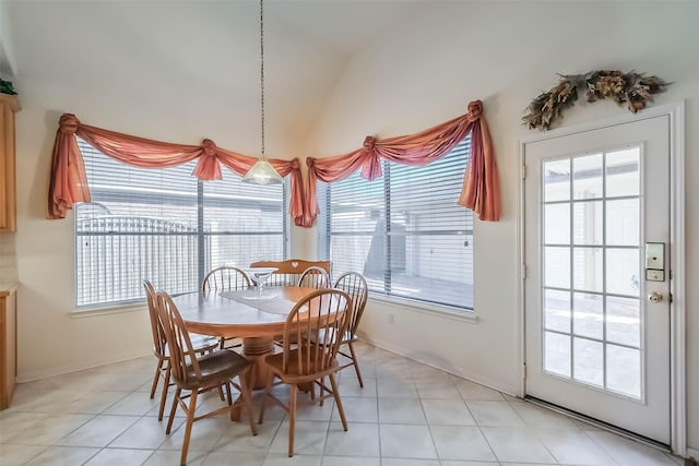 dining room with vaulted ceiling, plenty of natural light, and light tile patterned floors