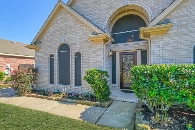 view of exterior entry with brick siding