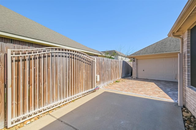 view of patio / terrace with fence and a detached garage